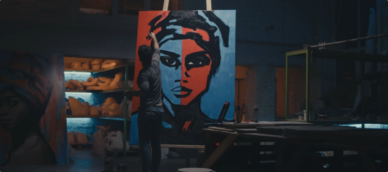 Artist painting a large portrait in the studio